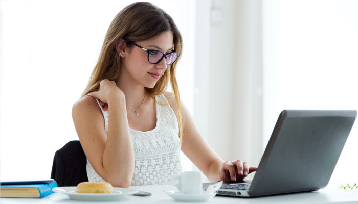 Mujer mirando en su notebook cómo crear una tienda online gratis.