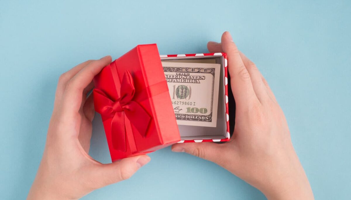 Dinheiro dentro de caixa de presente ilustrando fidelização de clientes com cashback