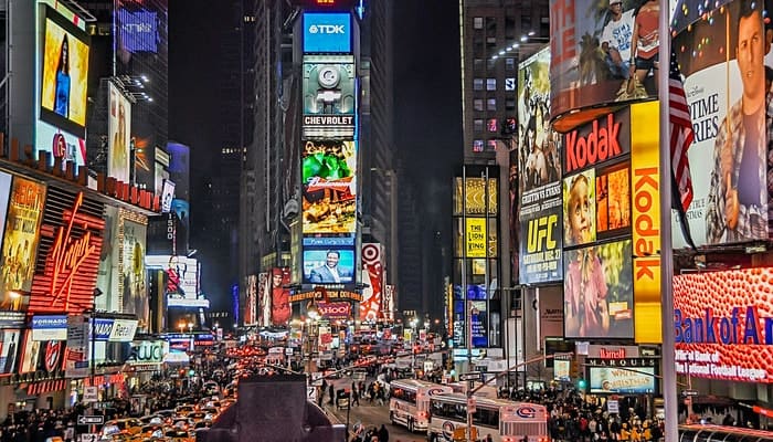 Imagem das Times Square Garden em Nova Iorque, mostrando telões com vários anúncios de marcas, representando o que é posicionamento de marca