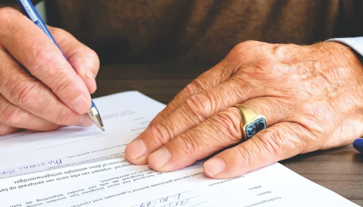 Imagem mostrando uma pessoa assinando um contrato, representando o processo de compra.