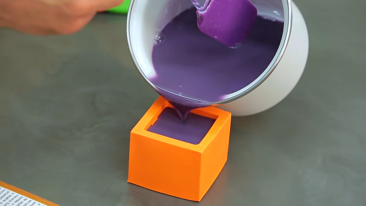 Imagem mostra a mistura para fazer sabonete artesanal para vender sendo despejada na forma de silicone