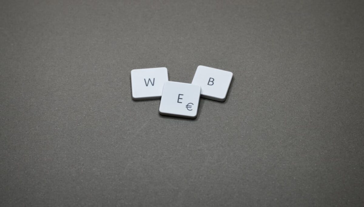 Peças de letras formando a palavra 'web' representam as siglas do marketing digital