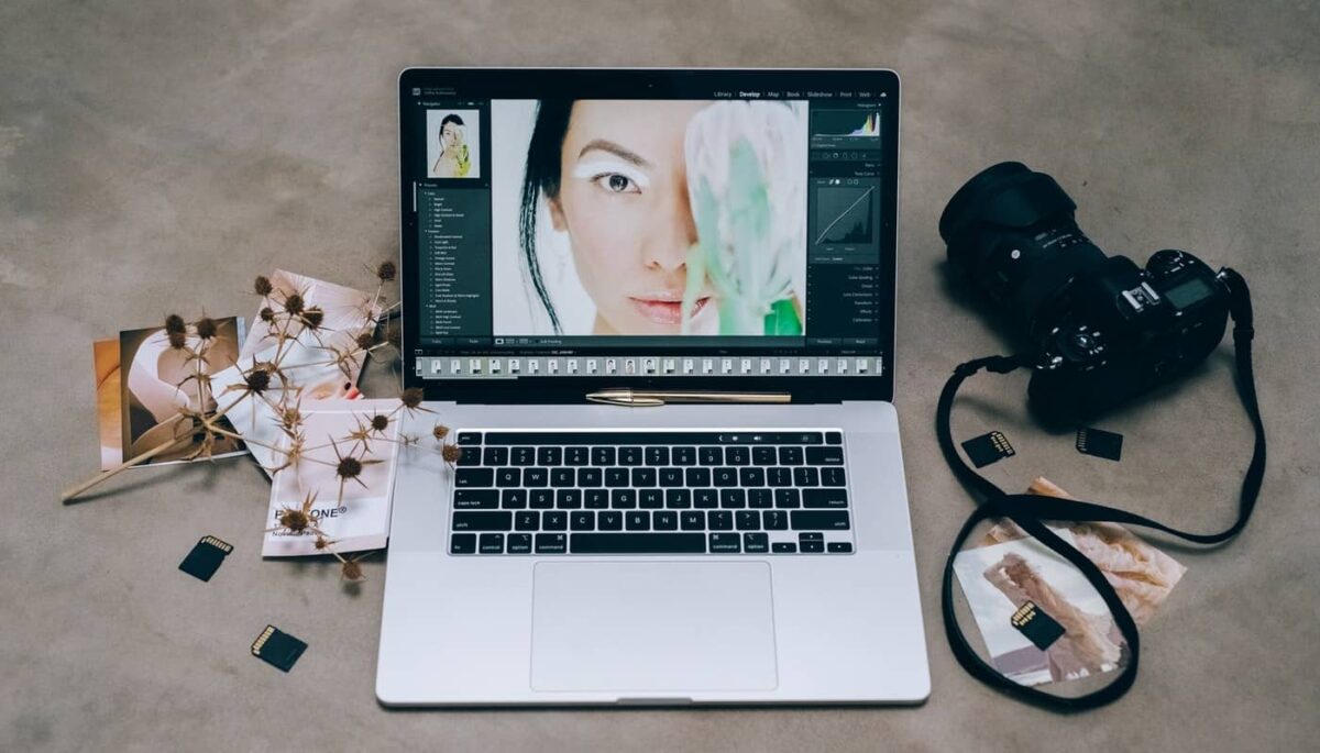 Imagem de um computador ao lado de câmeras fotográficas profissionais mostrando como vender fotos na internet