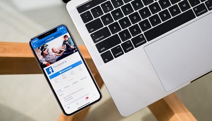 Una notebook y un celular mostrando cómo abrir una cuenta de Facebook