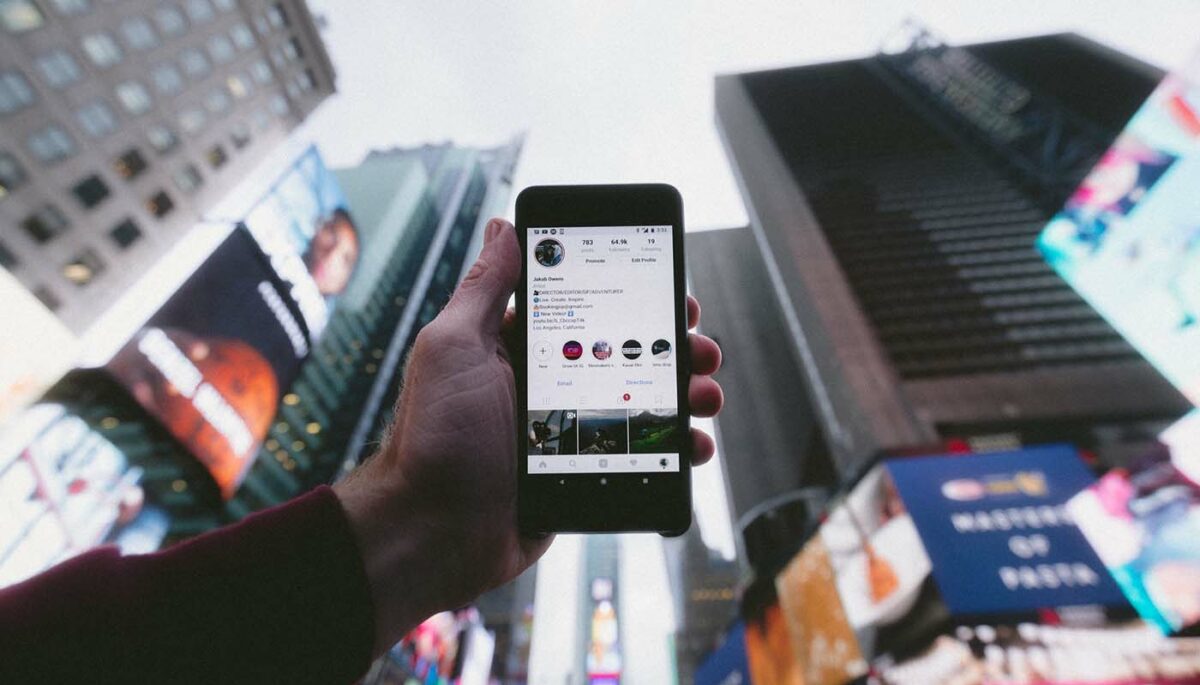 Foto de uma pessoa segurando um celular acessando o Instagram Business