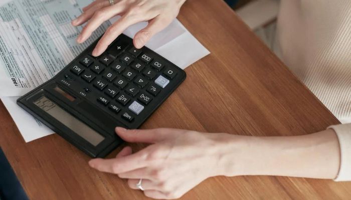 Mujer usando la calculadora para hacer una nota de crédito AFIP.