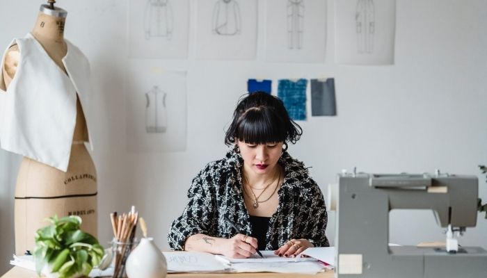 Mujer sentada en su escritorio anotando los tipos de empresas