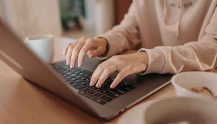 Una mujer escribiendo en su computadora sobre los tipos de sociedades