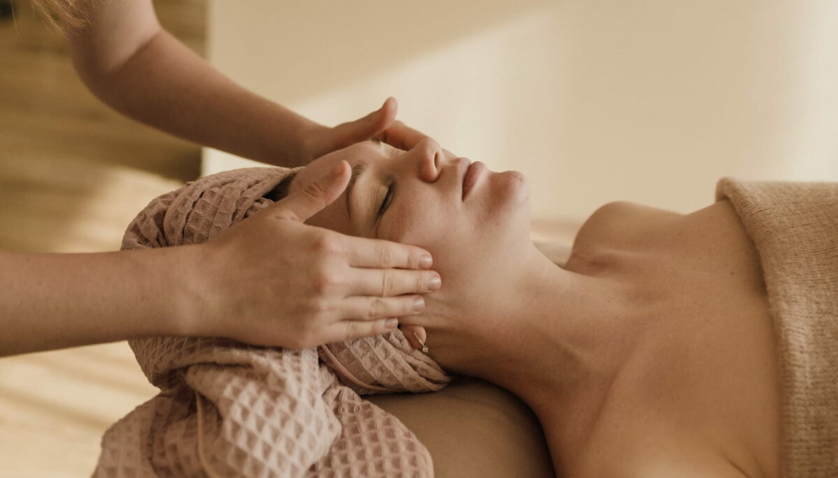 Mujer recibiendo un masaje facial como regalo saludable