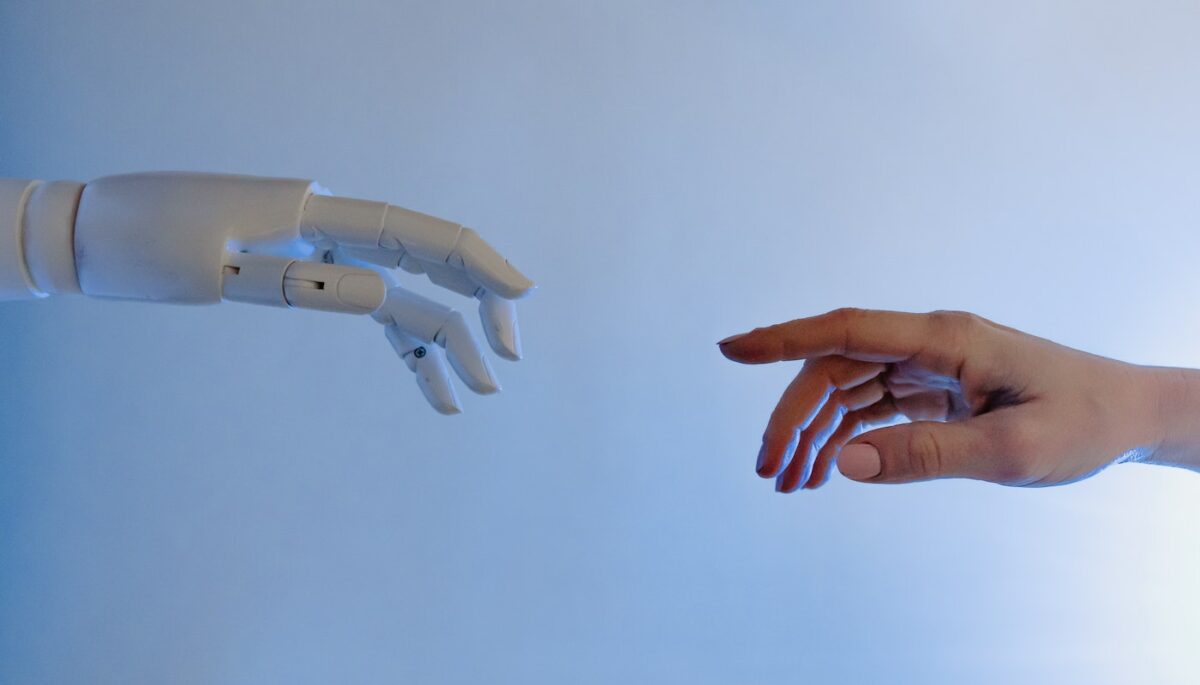 Imagem mostrando a mão de uma pessoa em contato com uma mão robótica, representando o sistema de busca inteligente.