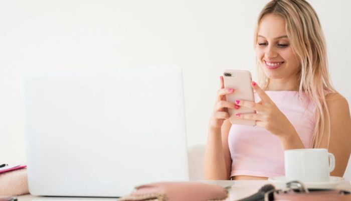 Mujer sentada mirando cómo publicar en Instagram en su celular.