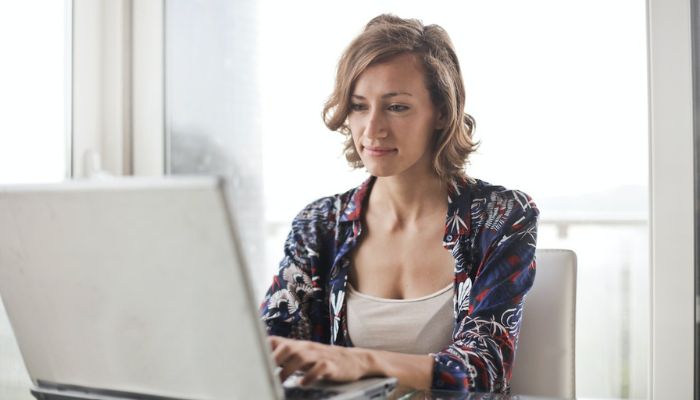 Mujer configurando un chatbot para su tienda online en su notebook.