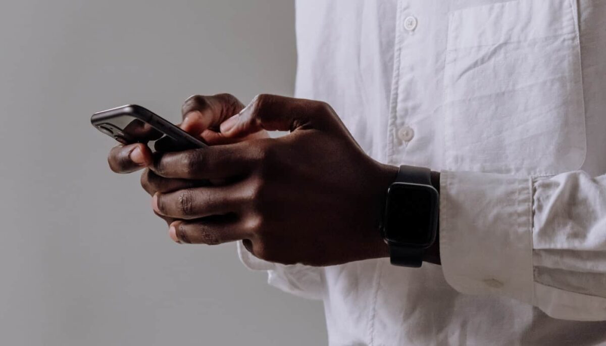 Imagem de duas mãos segurando um celular, representando atendimento via WhatsApp