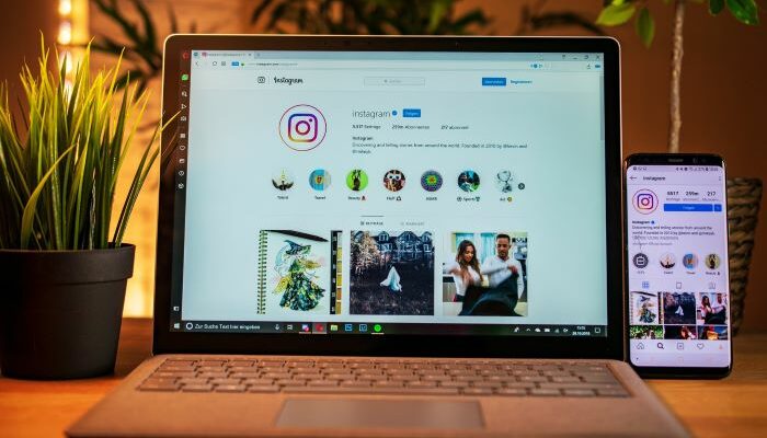 Una notebook y un móvil muestran ideas de descripciones para Instagram creativas.