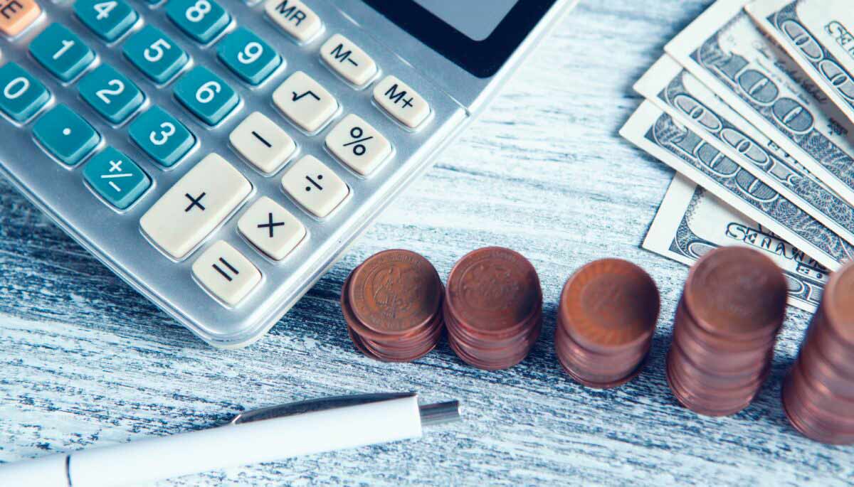 imagem de calculadora e moedas, representando a contabilidade financeira de uma empresa