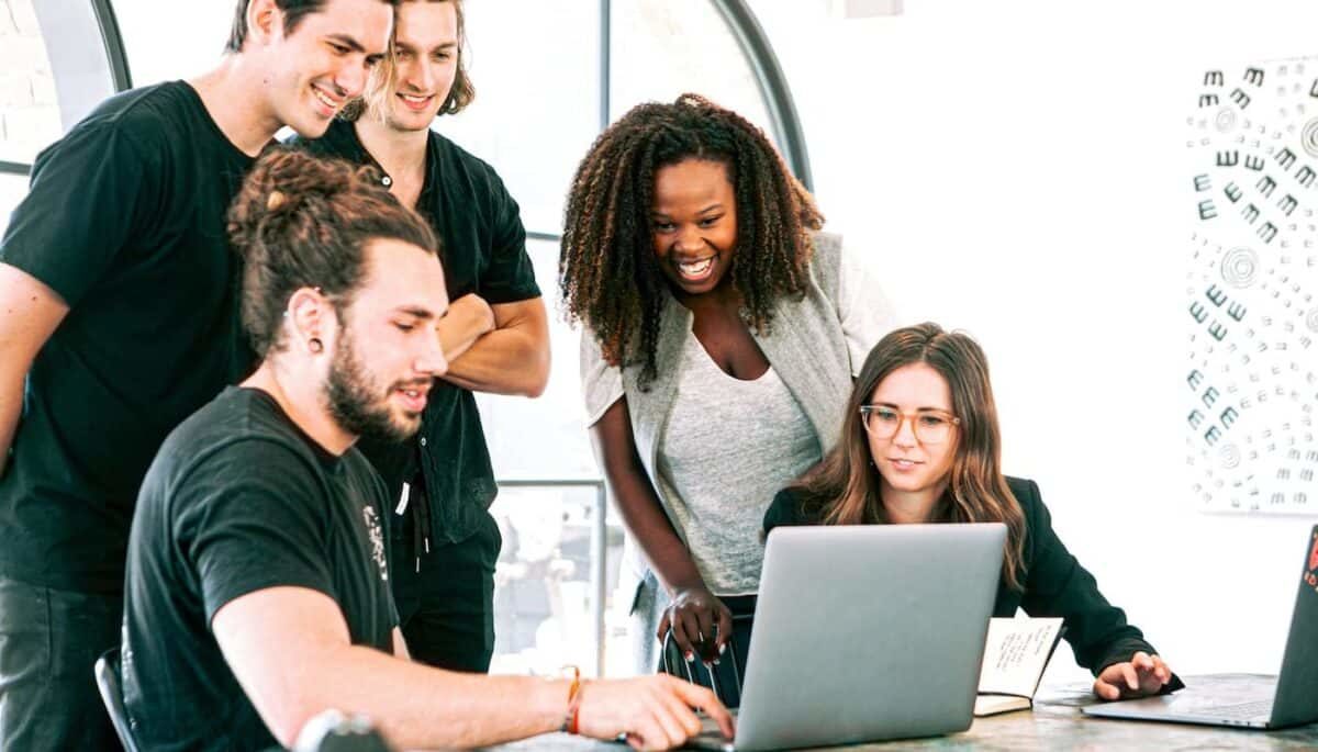 Grupo de pessoas em frente a um computador, como se estivessem planejando um novo negócio ao descobrir o que é startup.