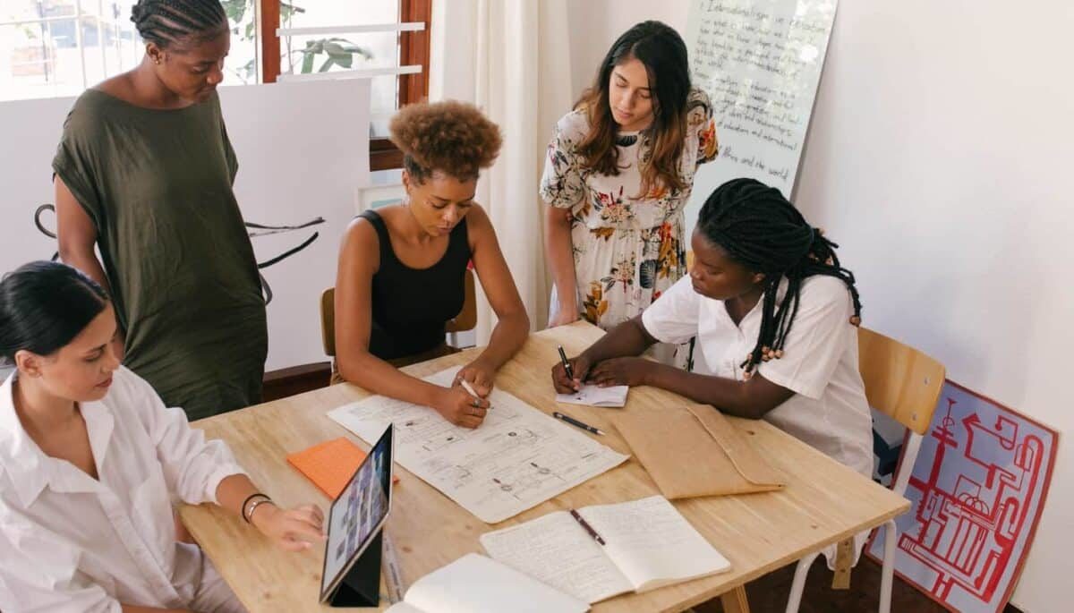 Imagem de mulheres trabalhando ao redor de uma mesa, representando o que é empreendedorismo feminino.