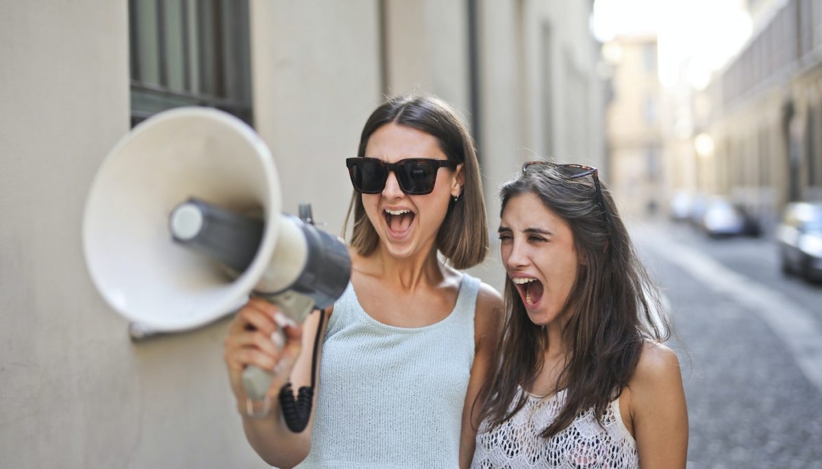 Imagem de duas mulheres usando frases para divulgar lojas