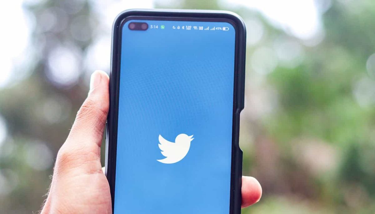 Imagem com logo do Twitter, um passarinho azul, na tela de um smartphone, simbolizando marketing no Twitter.