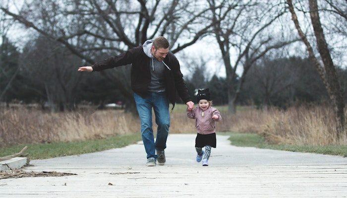 Padre e hija corriendo al aire libre y celebrando el Día del padre.
