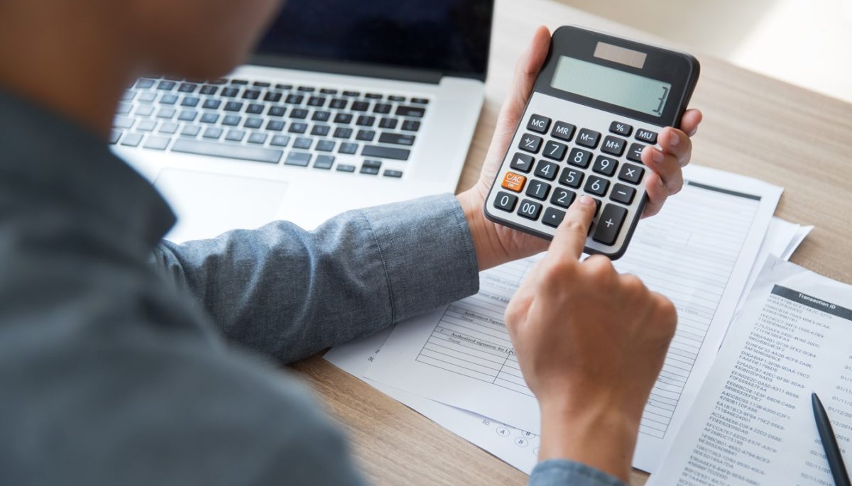 fotografia de un hombre con una calculadora que busca como ganar mas dinero como contador publico