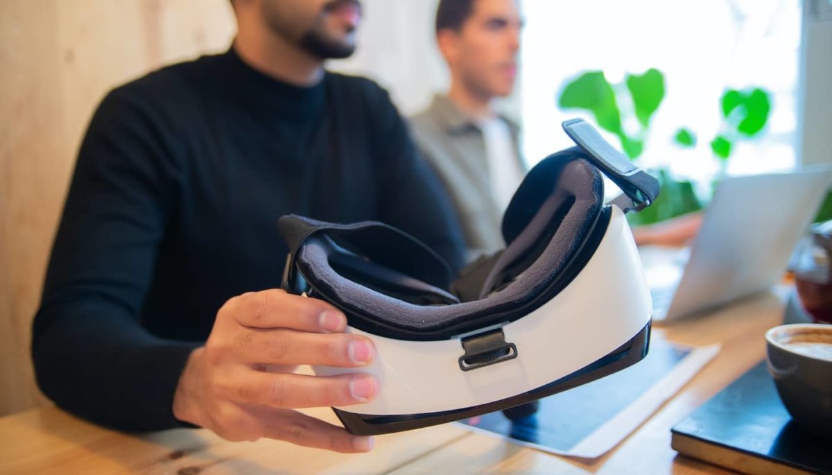 Homem segurando óculos de realidade virtual representando o metaverso no e-commerce