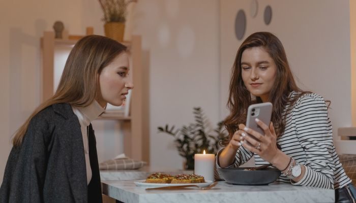 Dos mujeres leean cuándo es el CyberMonday en en un celular.