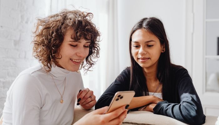 Dos mujeres viendo en un celular ejemplos de publicidad en Instagram.