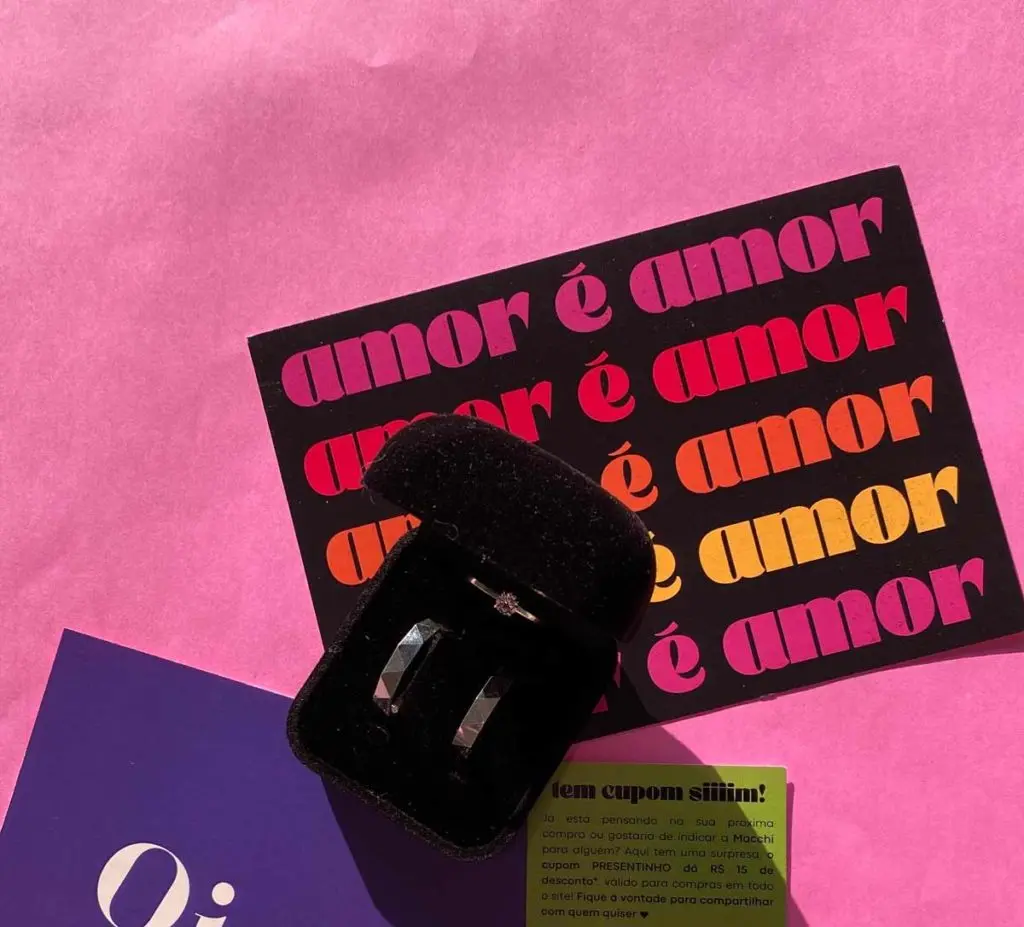 Par de alianças comercializado pela Macchi sobre um cartão escrito "amor é amor".