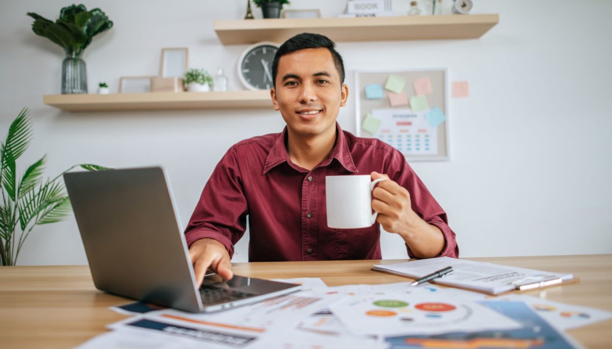 Hombre emprendedor en su computador tomando café colombiano