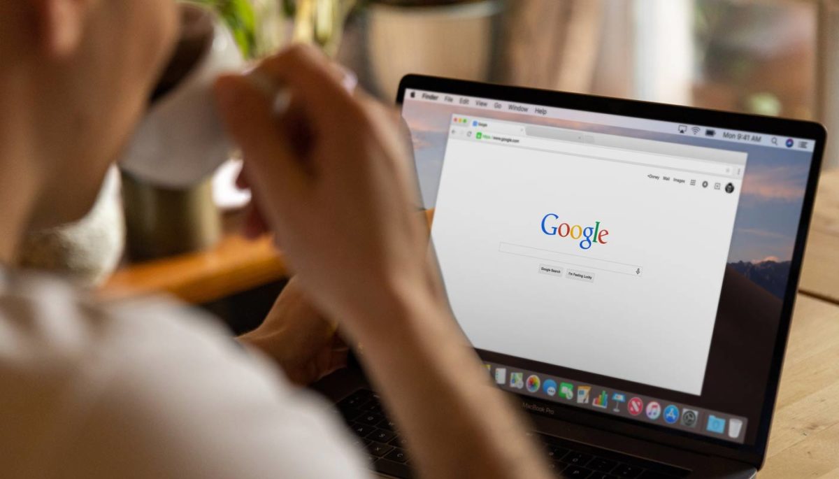 Empreendedor configura sua campanha Pmax do Google Ads enquanto toma um café com seu notebook.