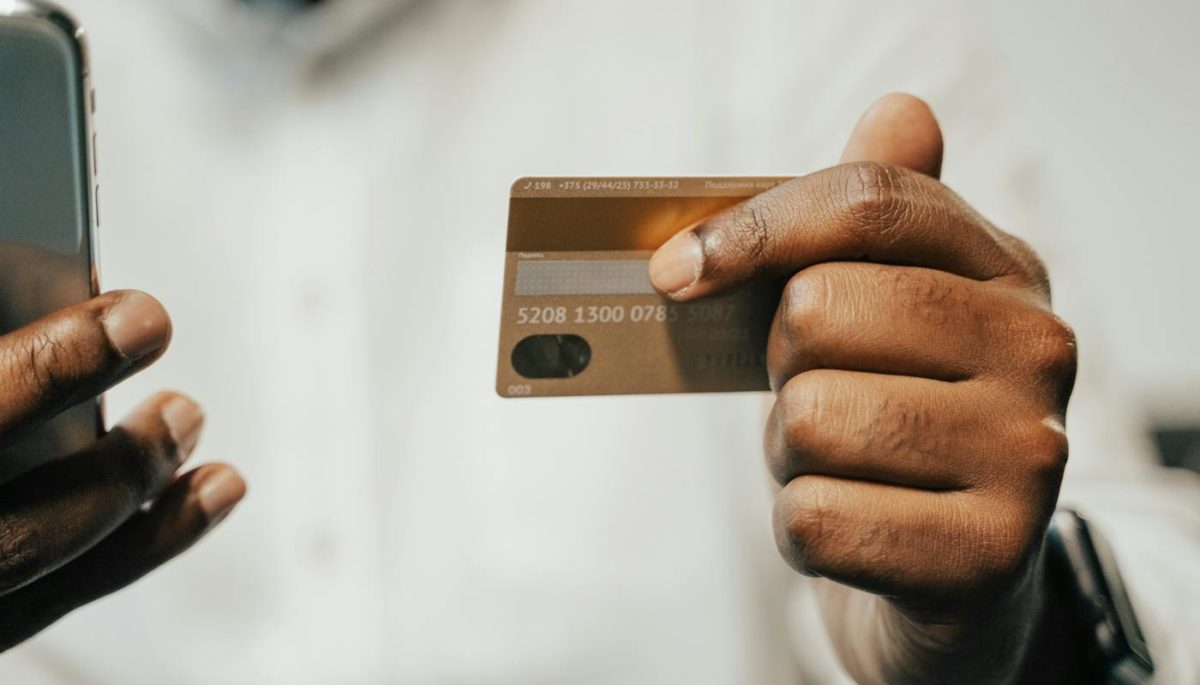 para ilustrar o texto como funciona o cartão de débito, homem confere na imagem dados do cartão para realizar compra online
