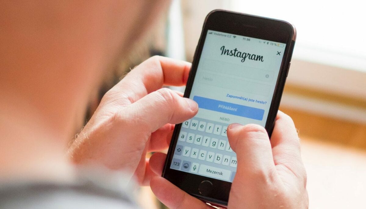Manos con celular iniciadas sesión en la página de inicio de la guía paso a paso sobre cómo recuperar una cuenta de Instagram.
