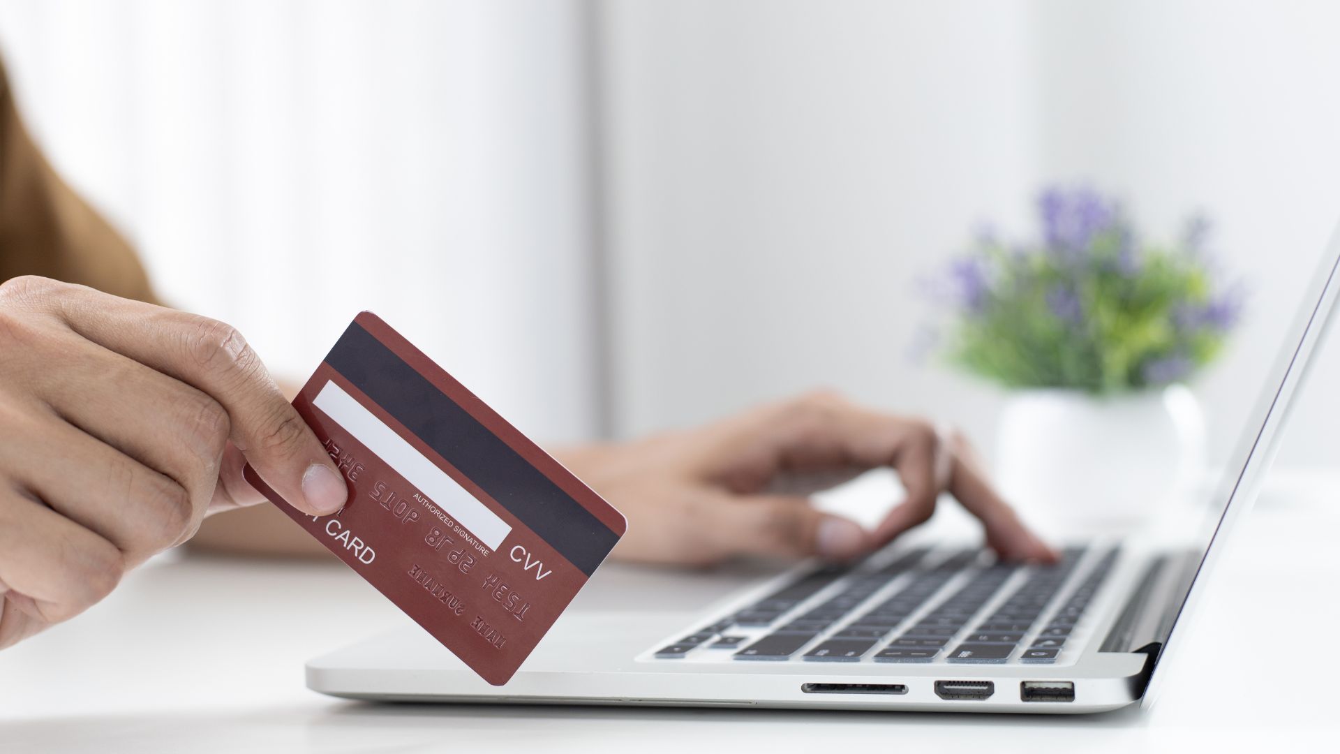 Persona realizando un pago con tarjeta de crédito en una tienda online.