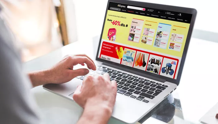 140 artículos que comprar en AliExpress para vender 2025 Una persona revisa qué vender en AliExpres en su computadora.
