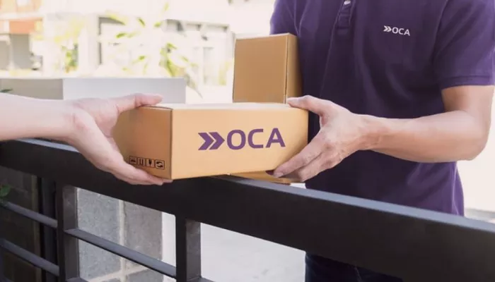 OCA Envíos: cómo funciona y cómo integrarlo a tu tienda Un repartidor de OCA envíos entrega un paquete al cliente de una tienda online.