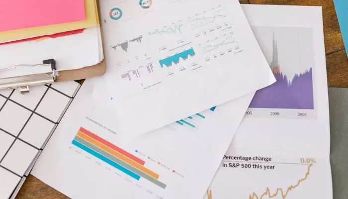 Tendencias de e-commerce 2025: las claves para potenciar tu negocio Papeles con gráficos sobre las tendencias en e-commerce para implementar estrategias efectivas y escalar marcas online.
