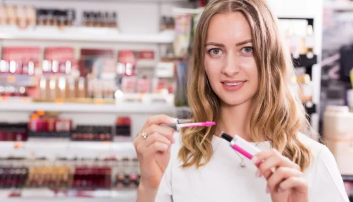 Mujer evaluando productos de belleza para vender. Uno de los negocios rentables en Colombia.