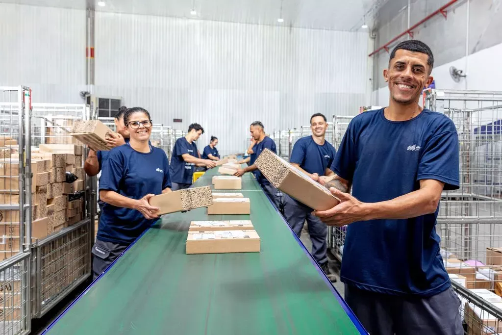 A imagem mostra a equipe da Mandaê em um centro de distribuição.
