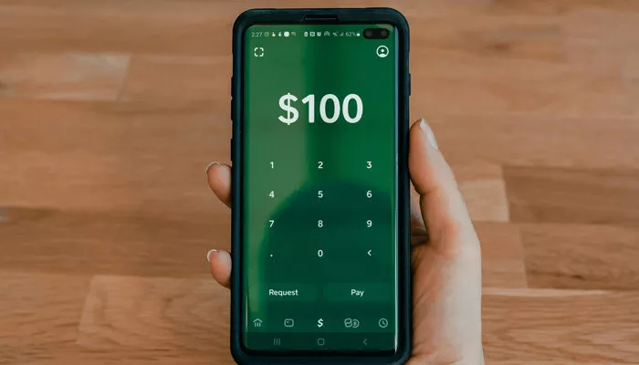 Persona realizando una transferencia bancaria desde su celular.